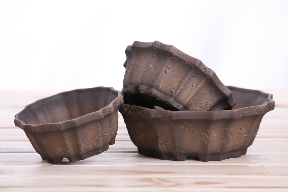 Three brown textured ceramic pots stacked together.