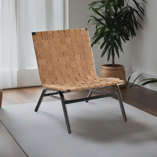 Camden Woven Brown Leather Accent Chair with woven leather back and seat, metal legs on a light rug in a minimalist room with a potted plant.