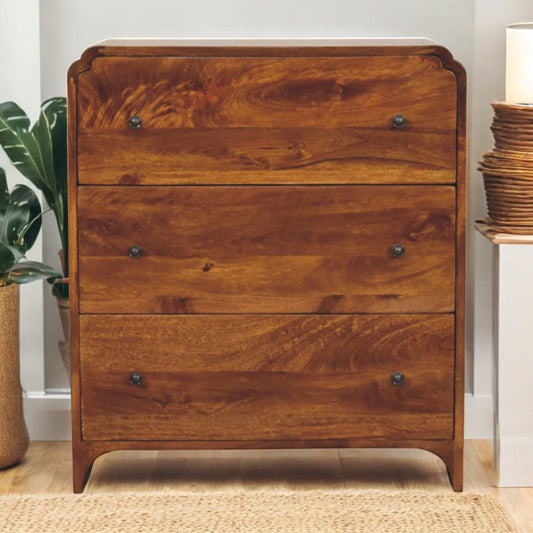 Solid Wood Newton Chest, 3-Drawers, Chestnut, wooden, natural finish, placed in a cozy room with a plant and a lamp.