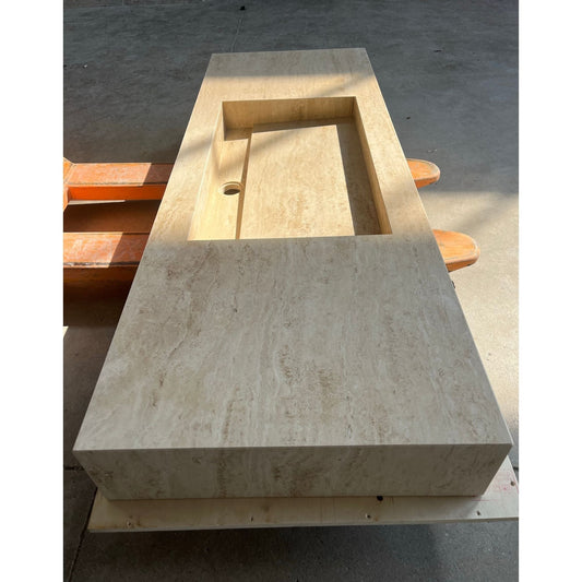 Rectangular travertine sink with a warm beige color showing natural stone texture.