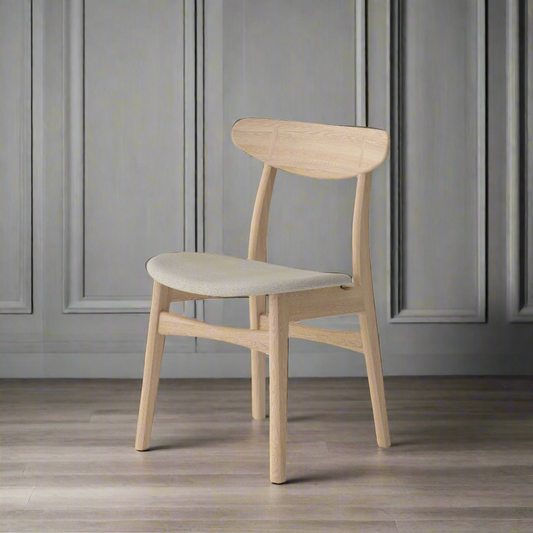 Mid-century style chair with solid oak wooden frame and upholstered fabric seat, light grey background with panelled walls