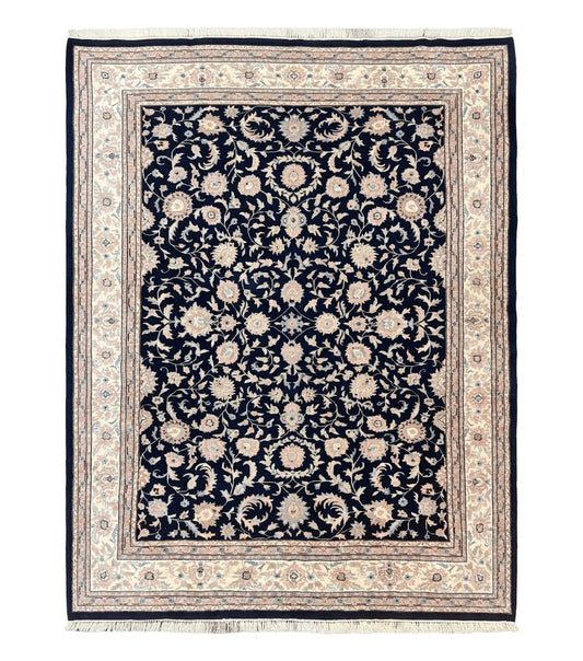 A navy blue and cream floral vintage handmade carpet with fringe edges.