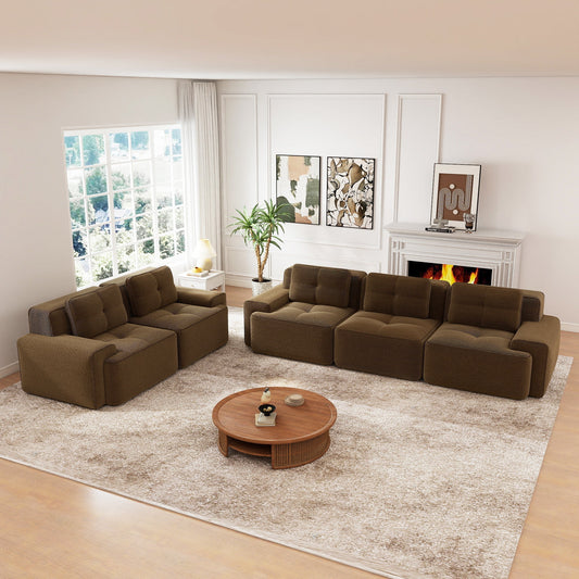 Modular sofa set in brown fabric with cushioned seating, placed on a rug in a living room with fireplace and artwork on the wall.