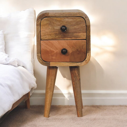 Small wooden bedside table with two drawers, natural wood finish, in a bedroom setting.