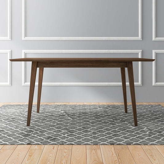 Dark wood rectangular dining table on patterned rug over light wood floor in room with grey wall