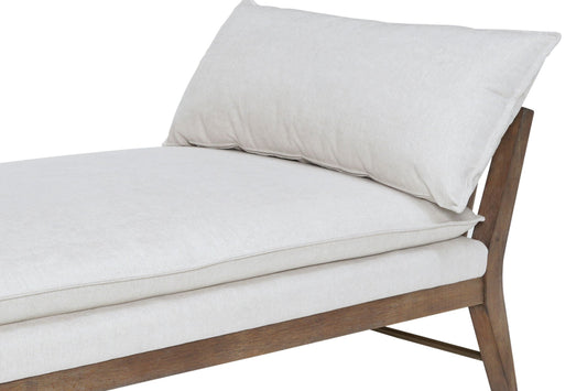 A light beige daybed with wooden legs and a rectangular pillow, against a plain white background.