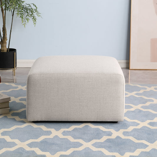 Light gray upholstered cube ottoman on patterned rug