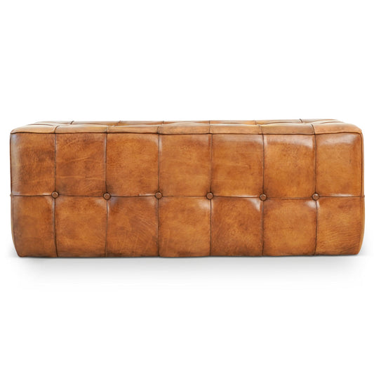 Rectangular tan leather bench with button tufting, photographed against a plain white background.
