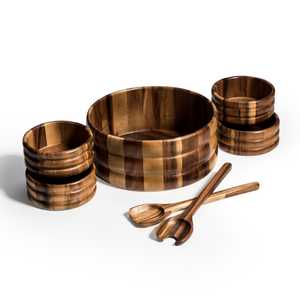 7 brown wood bowls with striped pattern, two wooden spoons, on plain background