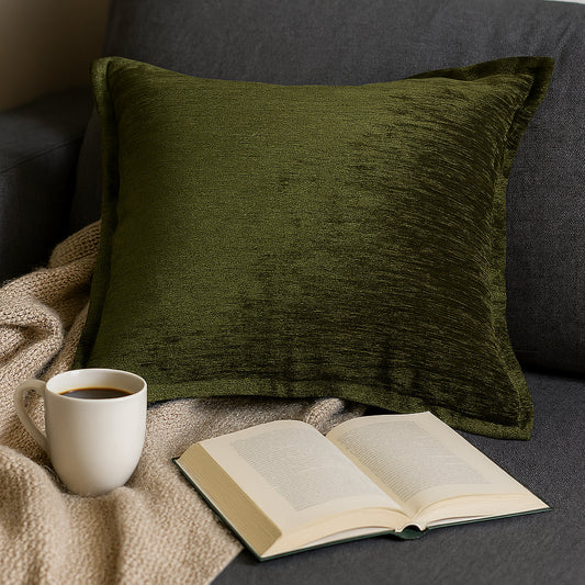 Deep Forest Green velvet throw pillow with luxe shine and rich texture, placed on a sofa with a cup of coffee and an open book.