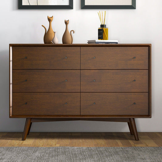 Wenge-colored wooden dresser with six drawers, featuring light brown cat-shaped vases and a yellow-labeled bottle placed on top, displayed in a room with a light gray wall and wooden flooring.