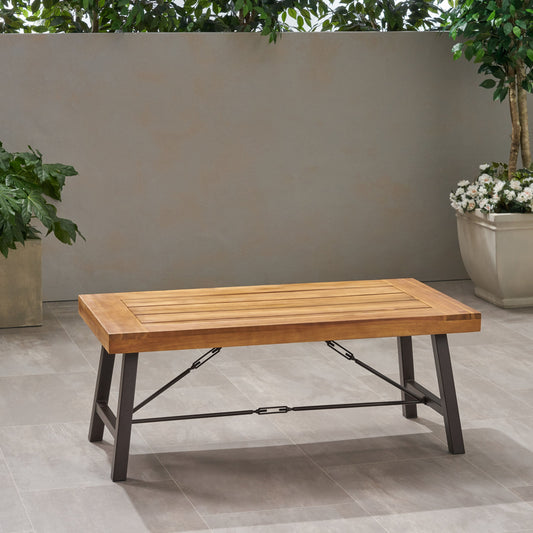 Rectangular outdoor Acacia wood coffee table with metal legs in a minimalist outdoor setting