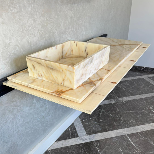 Calacatta Gold marble sink on floating platform over marble floor