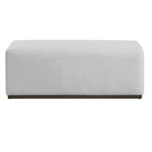 A simple rectangular footstool in light gray fabric with wooden base.