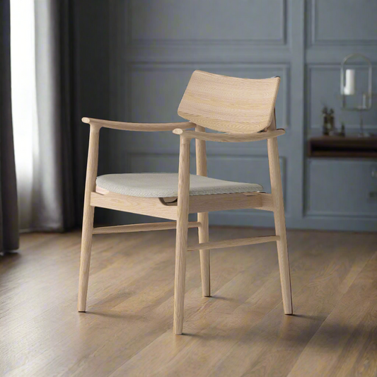 Elegant chair with solid oak wood frame and grey fabric cushion placed on light wooden floor in modern setting.