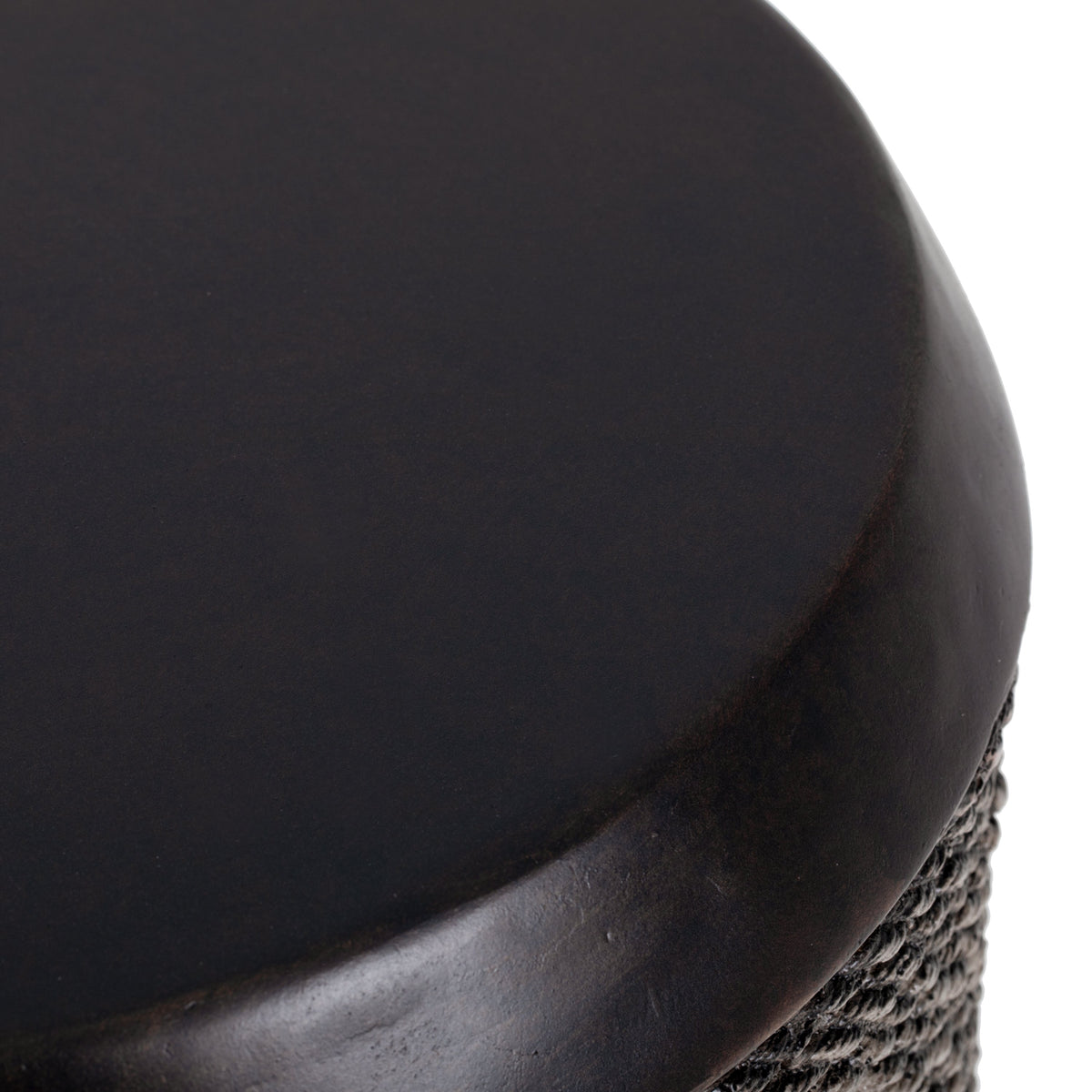A dark brown, glossy stool with a woven rope side section.