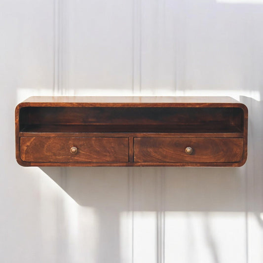 Rectangular solid wood console table with drawers, light brown finish, displayed on white panel wall, natural lighting and sunlight shadows visible