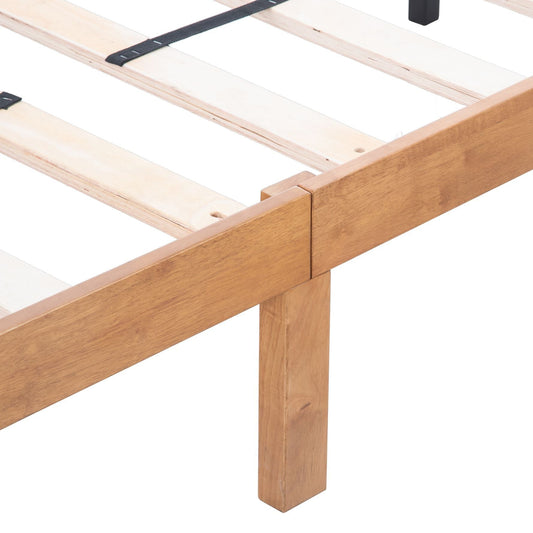 Low angle view of a solid wood platform bed frame with visible joints and internal slats.