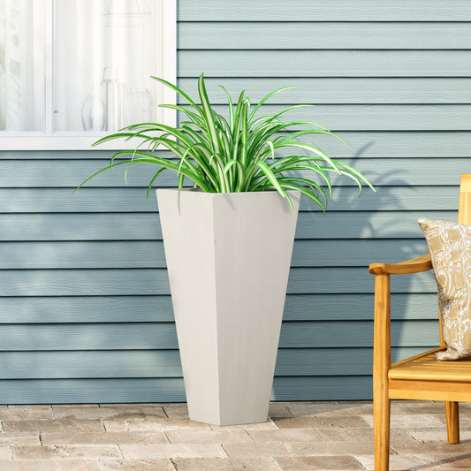 White tall outdoor planter with green plants; wooden bench and house siding in the background