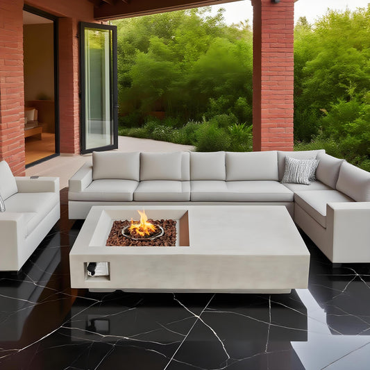 Modern concrete coffee table with built-in fire pit on a patio, surrounded by white sofas with cushions and brick wall in the background.