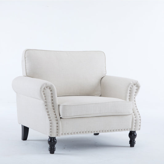 Beige upholstered armchair with nailhead trim, on black legs, simple background.