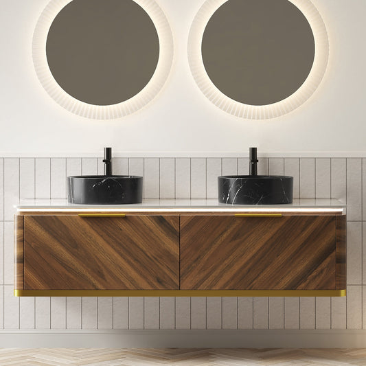 Double sink vanity with dark wood finish and black marble top, illuminated backlit mirrors above, grey tiled wall, herringbone flooring.