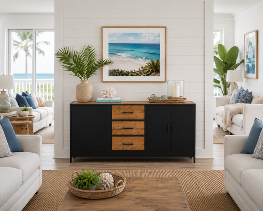 Dark wooden sideboard with lighter wood accents, displayed in a coastal-style living room with white cushions and a view of the ocean through the windows.