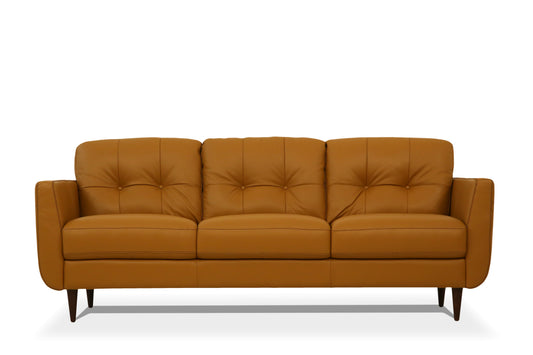 Vintage style camel leather sofa with tufted details and wooden legs against a white background