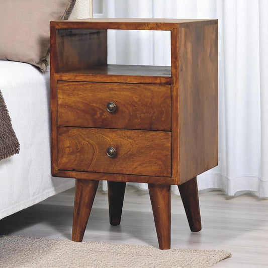 A solid wood mini classic chestnut bedside table with an open shelf and two drawers, positioned in a cozy bedroom setting.