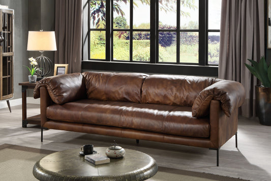 A brown leather sofa with distressed texture, placed in a modern living room setting.
