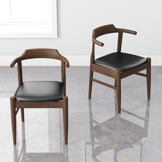 Two black leather dining chairs with wooden frames on a tiled floor, minimalistic white background.