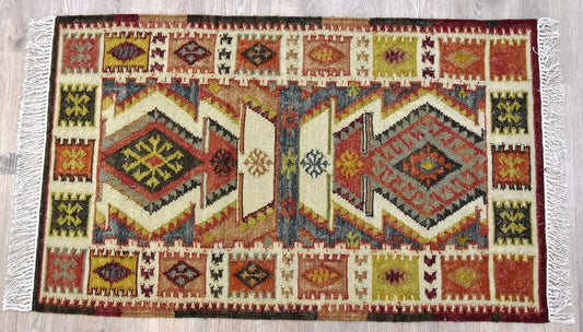 A Rust Wool and Cotton Handmade Kilim Rug with geometric and diamond patterns in shades of red, yellow, green, and white.