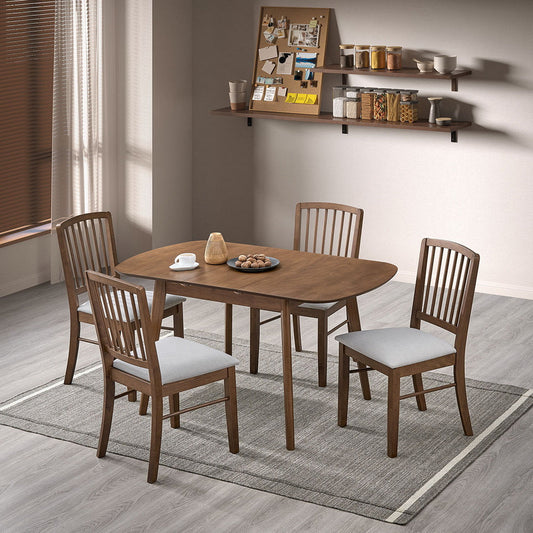 Walnut-finished extending dining table set in wooden chair with cushioned seats on light rug in white-paneled room.