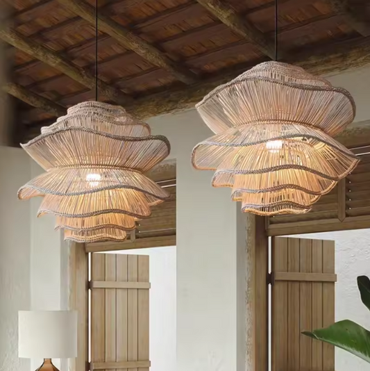 2 handcrafted rattan pendant lights hanging from wooden beams in a rustic setting