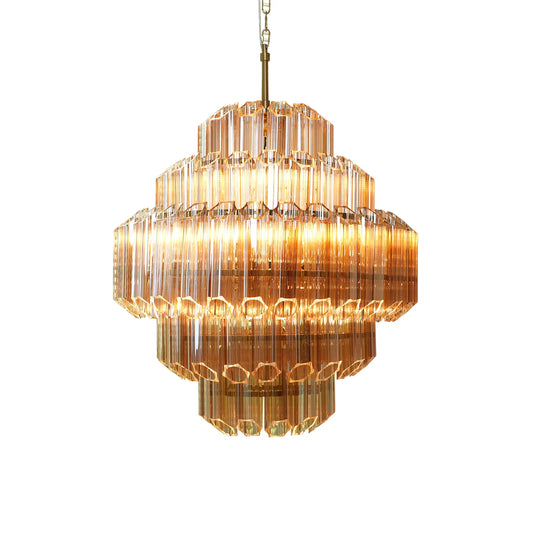 Multi-tiered chandelier with clear glass tubes, gold finish; glowing light source visible.