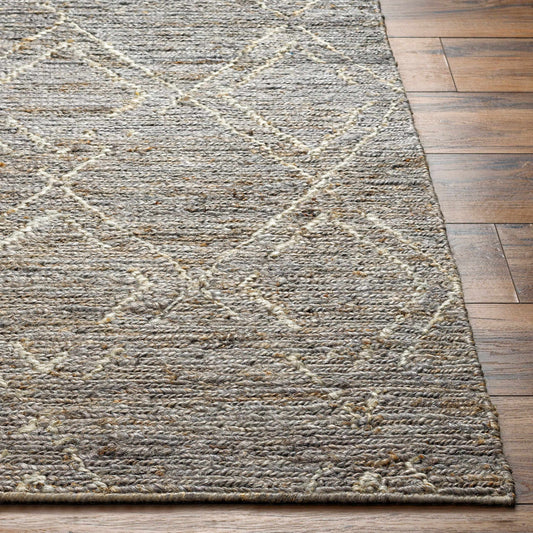 A jute carpet with a subtle pattern lies on a wooden floor.