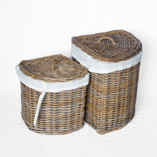 Rattan woven corner laundry baskets with lids and white lining, natural finish, light background.