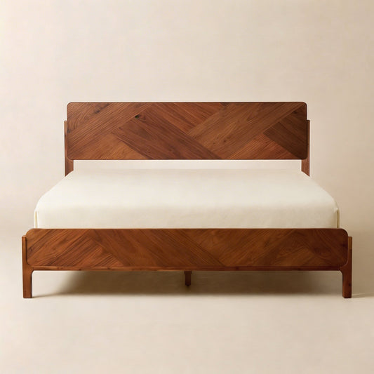 A wooden bed frame with a herringbone pattern, placed against a plain wall, with a white mattress.