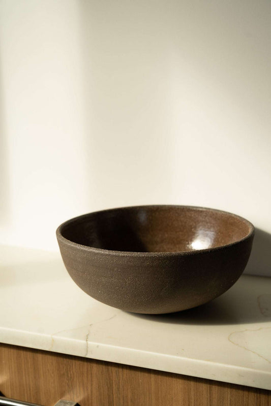 Stoneware large brown bowl on a marble countertop