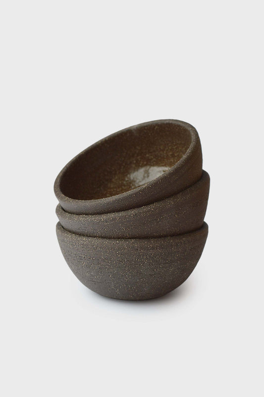 Three stacked handmade stoneware mini bowls with a speckled finish in a muted brown color.