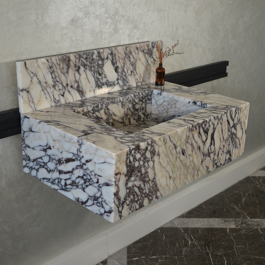 Rectangular marble sink with intricate natural patterns, light grey wall, dark floor with white veins, wall-mounted.