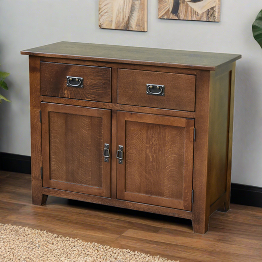 Mission 2-Door 2-Drawer Sideboard, Console in Walnut Finish on hardwood floor with beige rug, artwork on wall, partial plant visible.