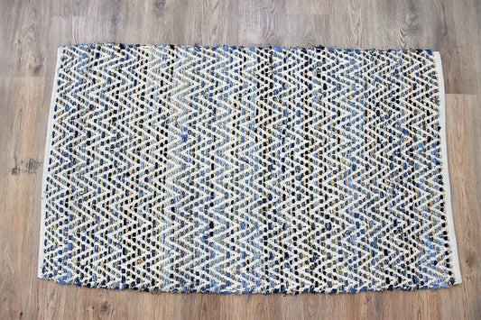 Blue and beige patterned rug on rustic wooden floor