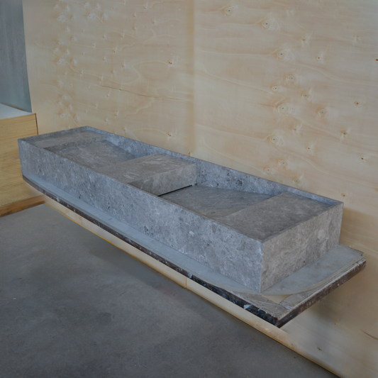 Large grey marble sink on display in a studio setting
