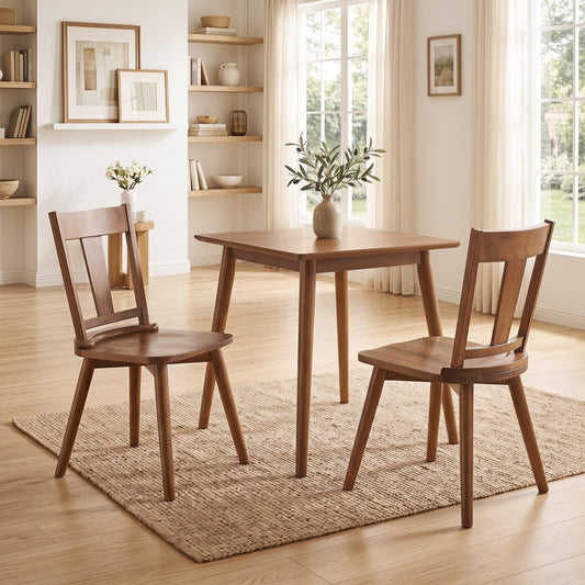 Two solid wood dining chairs with ergonomic backrests next to a wooden table on a woven rug in a minimalistic room with wooden flooring and light curtains.