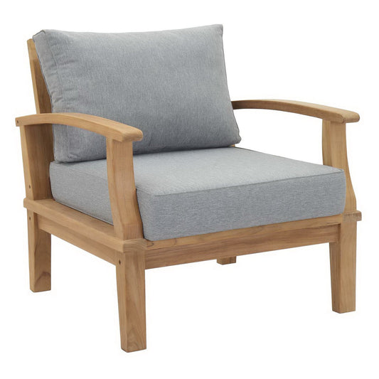 Teak armchair with cushioned seat and backrest against plain background.