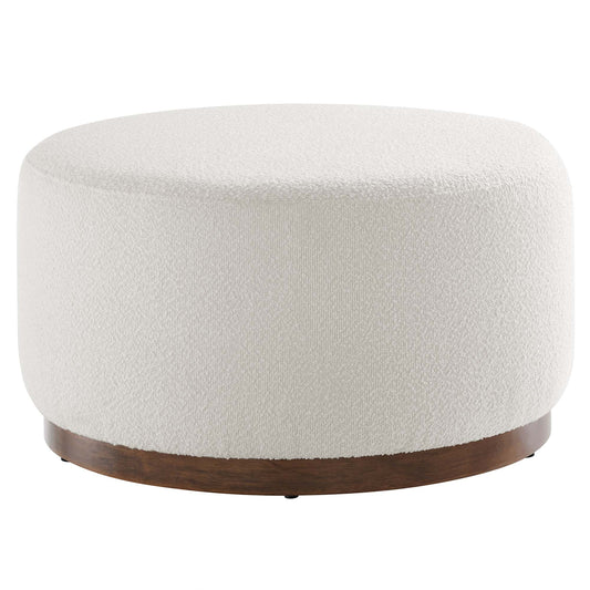 A round white upholstered ottoman with a textured bouclé fabric and a dark wood base, viewed from above.