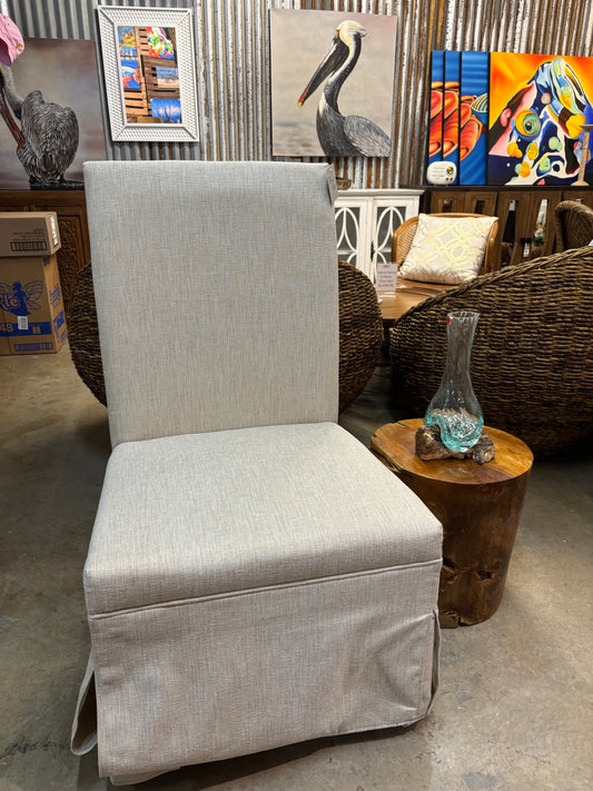 Sleek beige lounge chair with a textured fabric, styled with a wooden side table and decorative vase in a retail setting