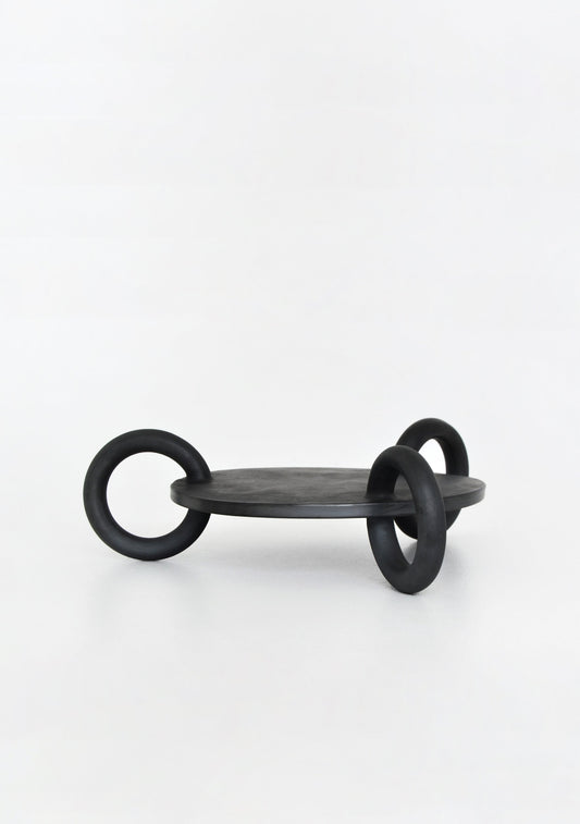 A wooden serving platter with three circular handles, black in color, set against a plain white background