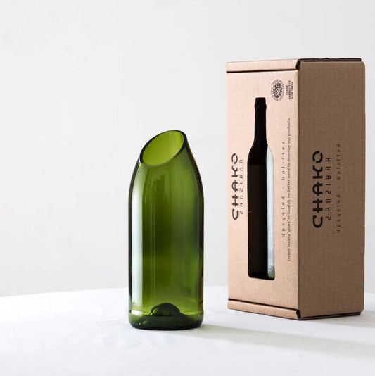 Green recycled glass vase by Chako Zanzibar beside branded box on white surface